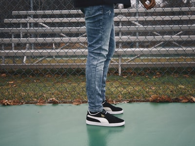 Wearing blue jeans and black and white adidas sneakers
